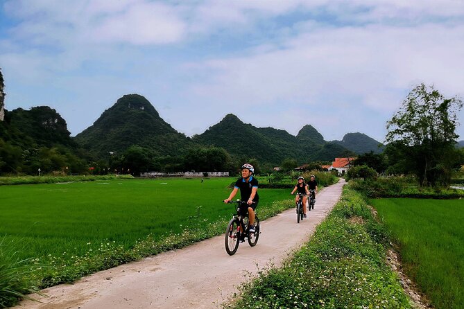Hoa Lu - Tam Coc - Ninh Binh Day Tour: Biking, Visit Local Family - Cycling through rice fields near Tam Coc