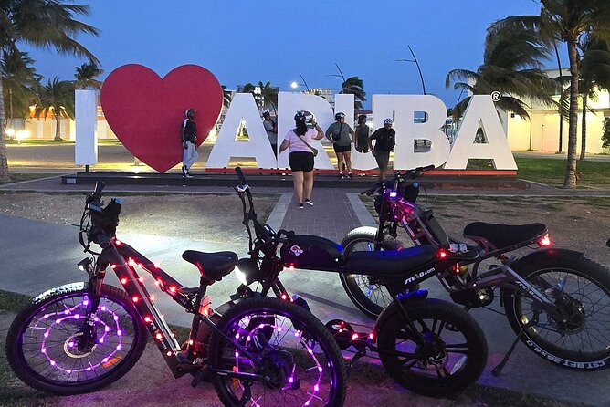 Semi-Private Christmas Edition Twilight Glow E-Bike Oranjestad - Plaza Turismo and the Aruba sign